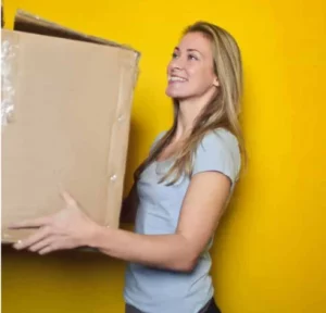 mujer moviéndose sosteniendo una caja y manteniendo su servicio eléctrico